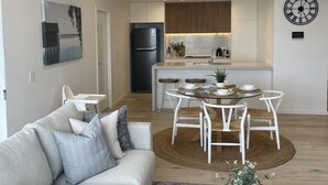 Una sala moderna con sofá, mesa de centro y comedor con mesa y sillas.