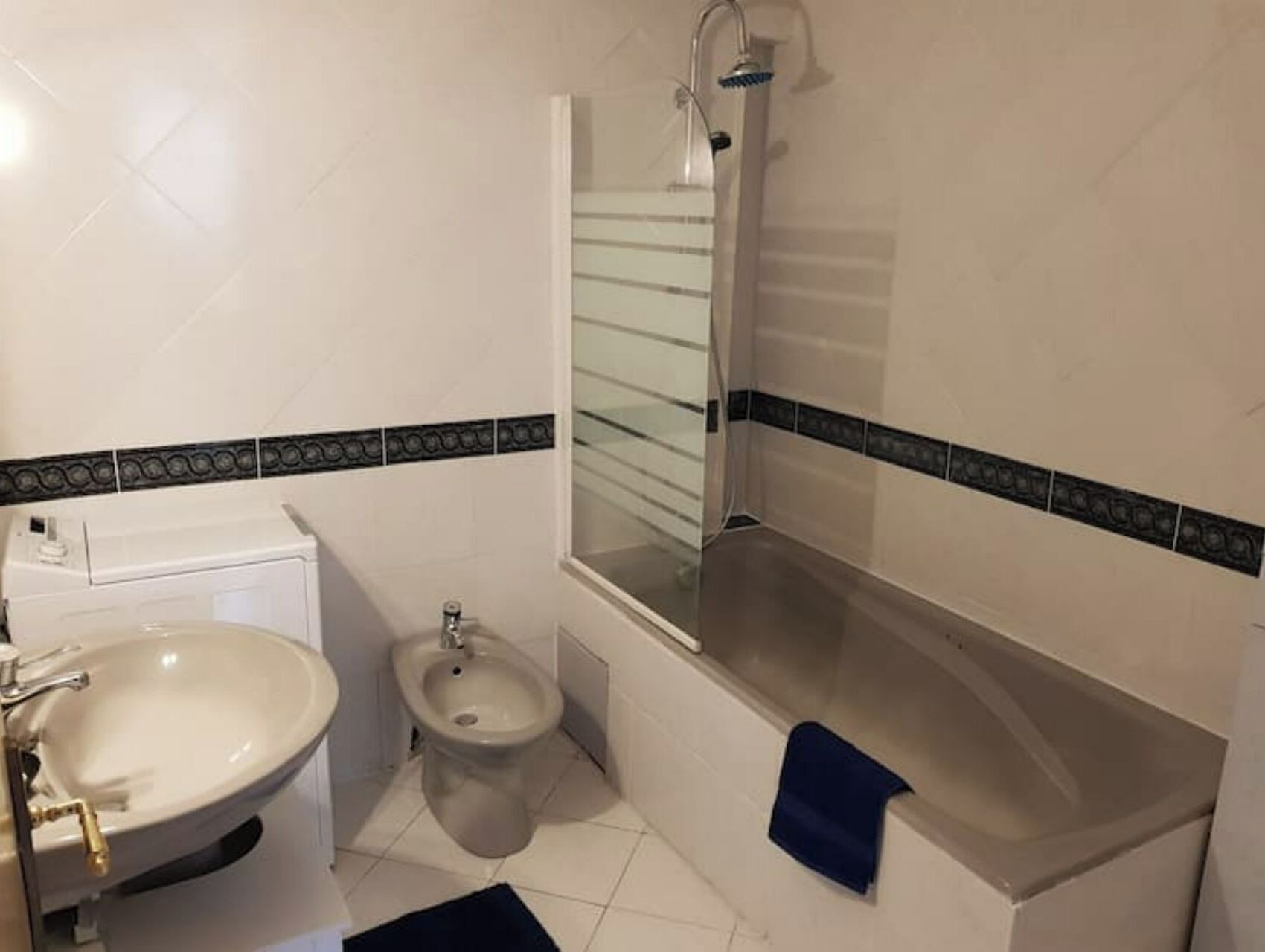 A bathroom with a white sink, bidet, and bathtub.