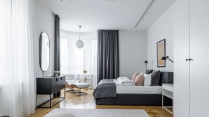 A modern bedroom with a bed, bedside table, and a desk.