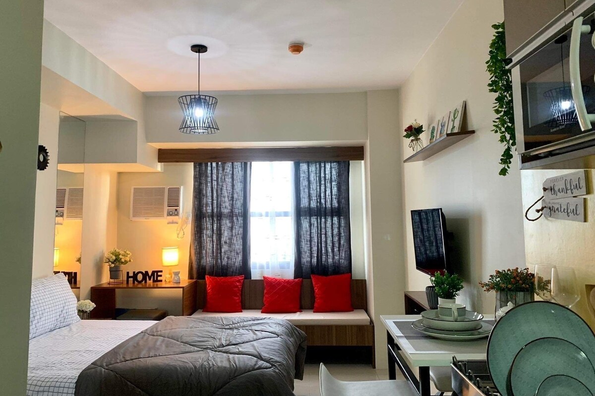 Un dormitorio moderno con cama, escritorio y televisor.