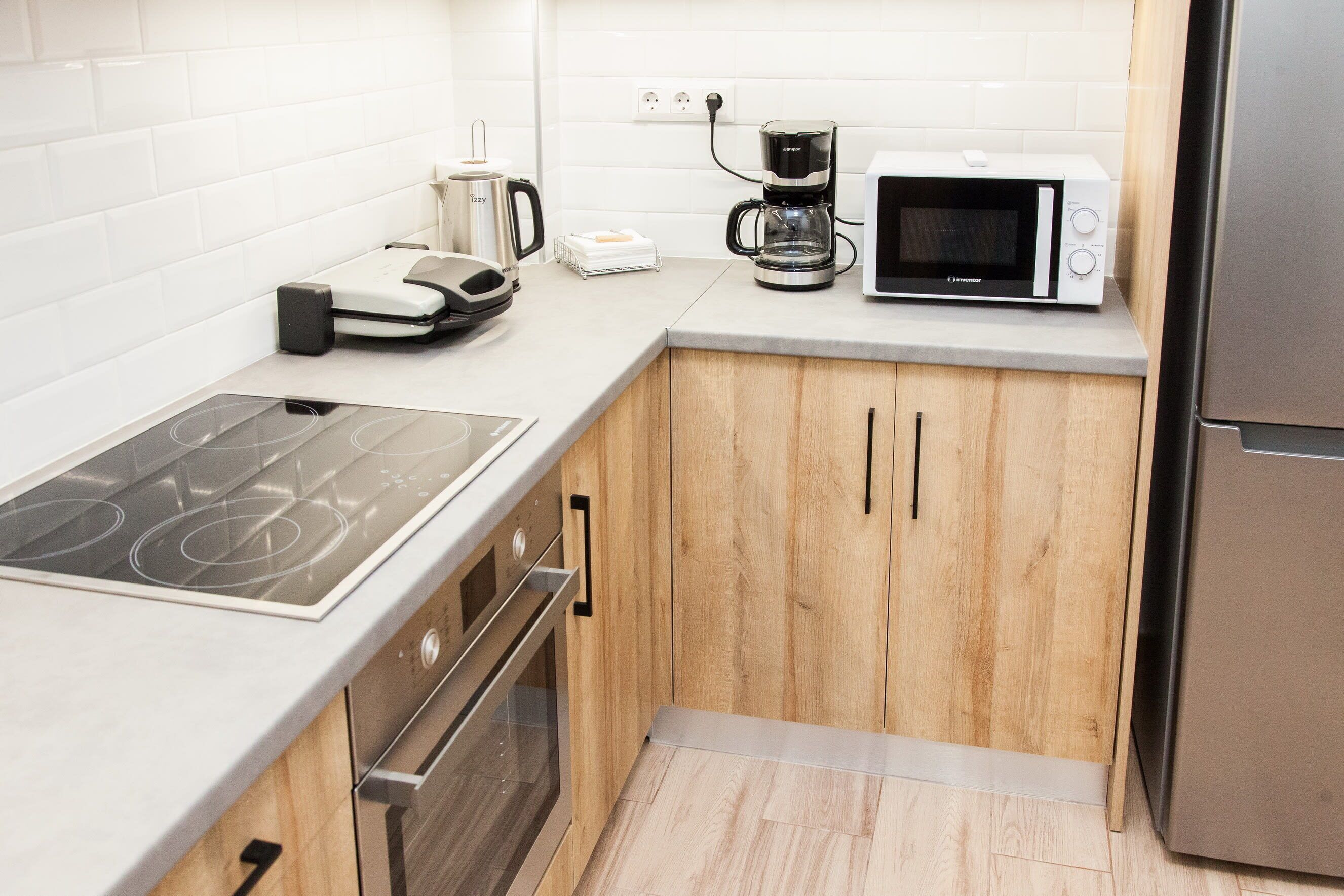 A compact kitchen with a built-in stove, oven, microwave, and coffee maker.