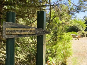 Ein hölzernes Wegweiser mit der Aufschrift 'MALZOWER REETHUUS', der nach rechts zeigt.