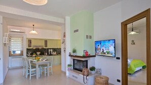 Una cocina moderna con comedor, chimenea y televisor montado en la pared.