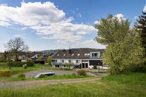 A residential area with houses, a paved driveway, and a car. - Wagners Landhaus (Mehren)