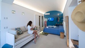 Ein modernes Wohnzimmer mit einer Couch, einem Bett und einem Fernseher.
