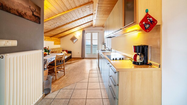 A kitchen with a wooden ceiling, a coffee machine, and a window. - Apartment "Lingerhof - Alpenrose" with Mountain View, Shared Garden & Wi-Fi (Mölten)