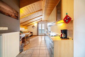 Une cuisine avec un plafond en bois, une machine à café et une fenêtre.