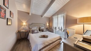 A bedroom with a large bed, bedside tables, a desk, and a window with curtains. - Maison De Charme in Sorrento (Sorrento)