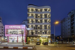 Un edificio de varios pisos con una sucursal de TTR Central y una tienda Concung en la planta baja.