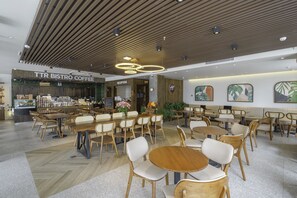 Un moderno café bistró con mobiliario de madera y una zona de recepción.