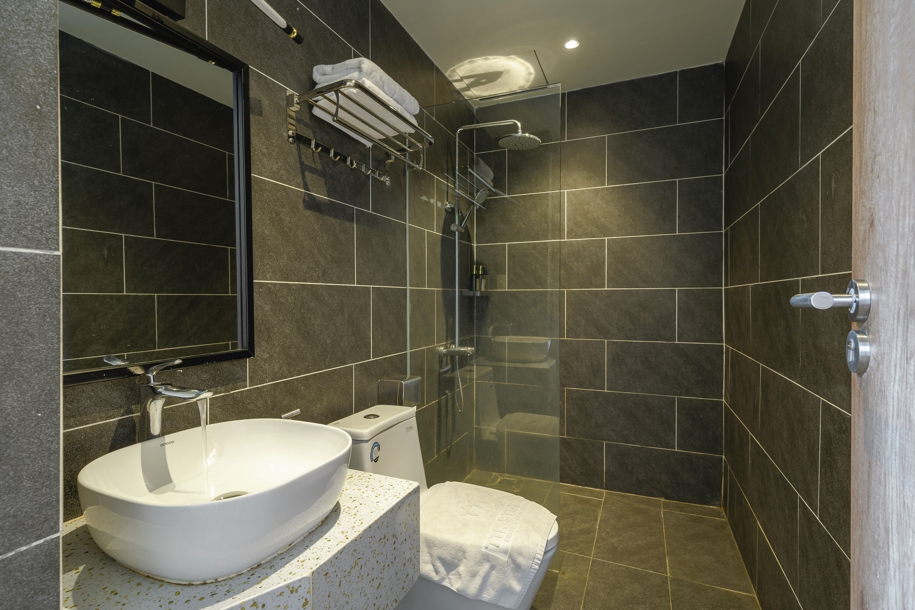 A modern bathroom with a white sink, a toilet, and a shower area.