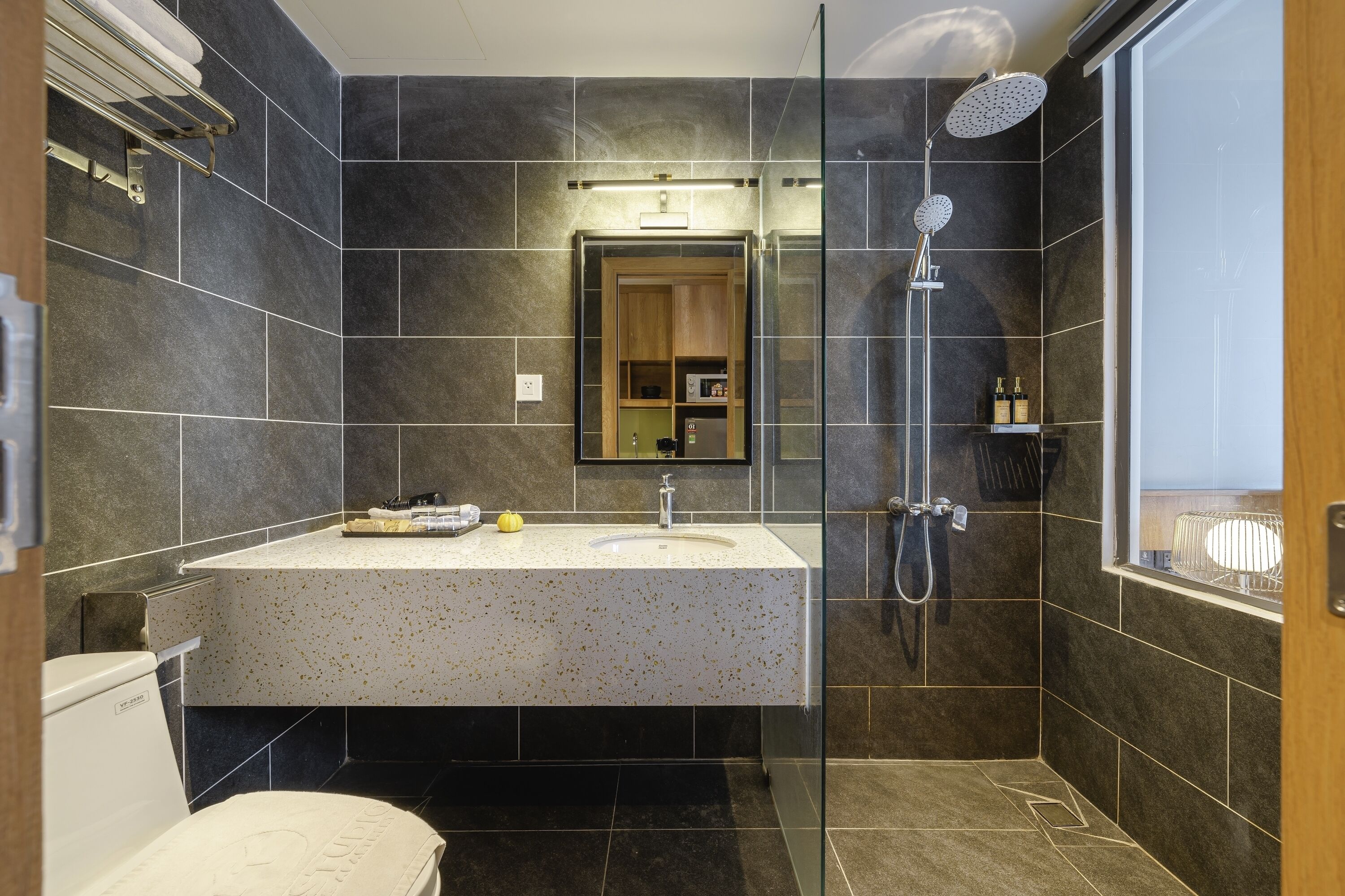 A modern bathroom with a freestanding sink, a glass shower enclosure, and a large mirror above the vanity.
