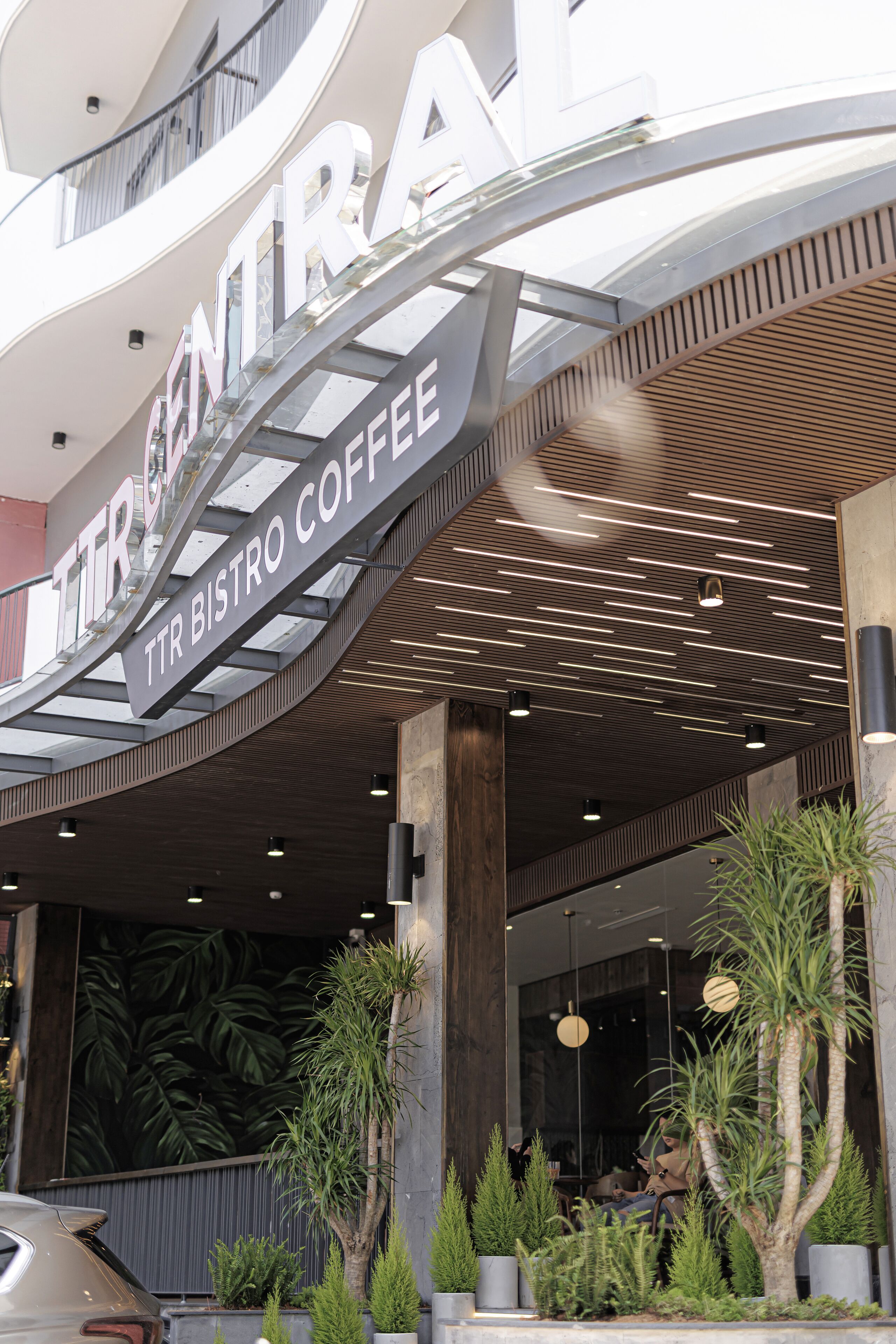 A modern building with a sign reading "TTR BISTRO COFFEE" and a glass entrance.