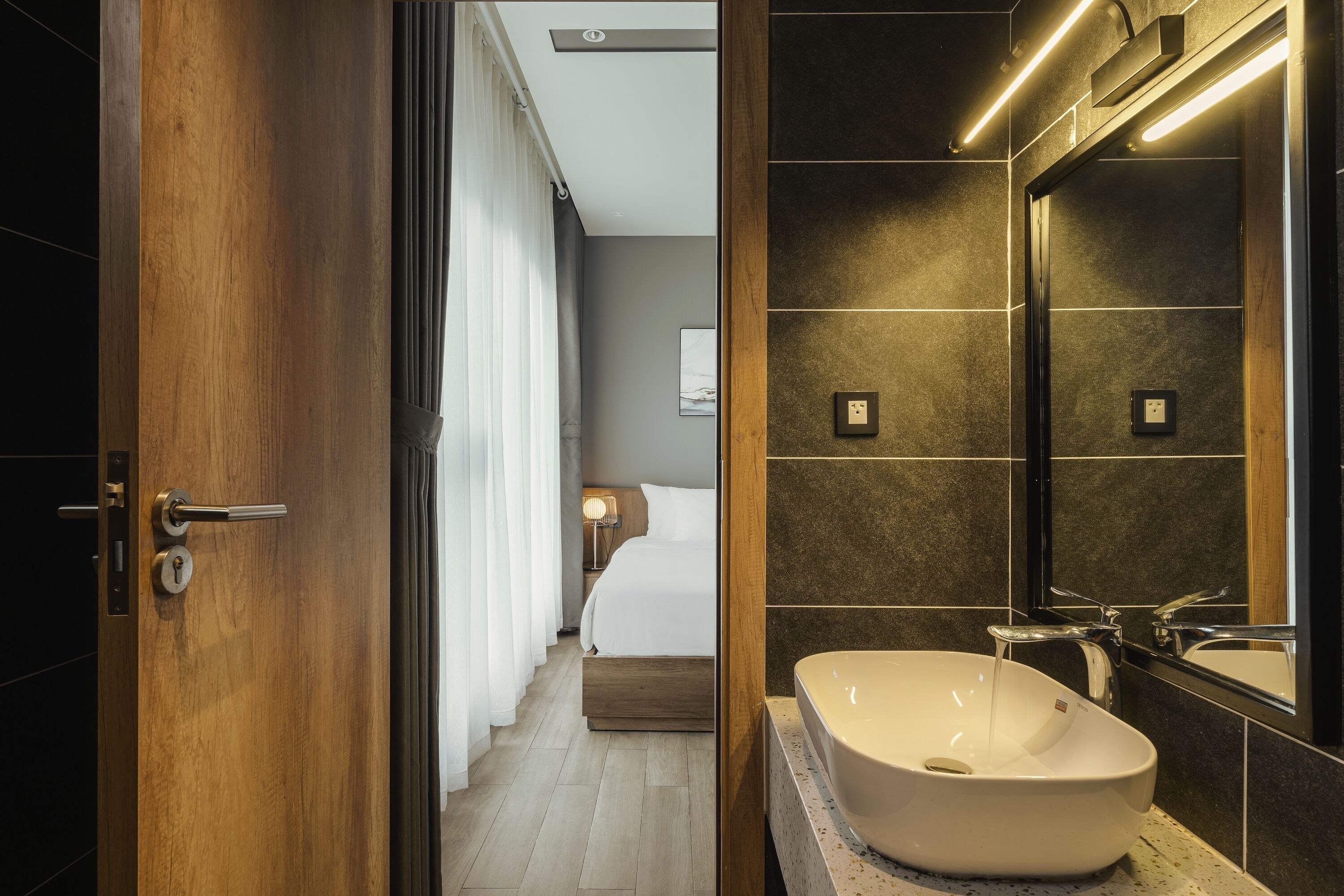 A modern bathroom with a large sink, a mirror, and a shower.