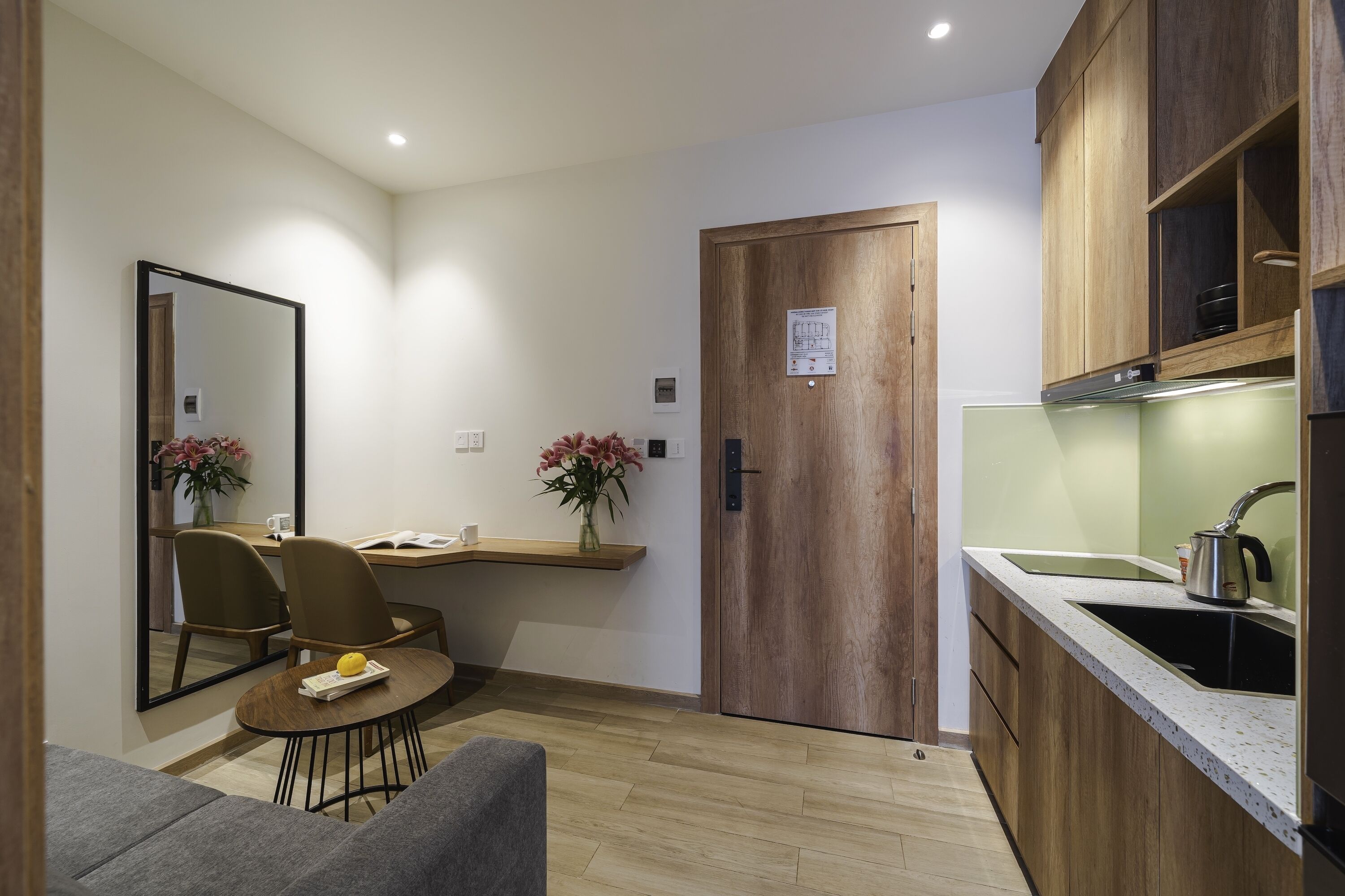 Una cucina compatta con mobili in legno, un lavello e una zona pranzo con tavolo e sedie.