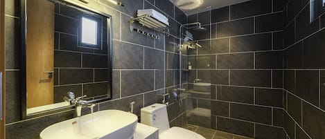 A modern bathroom with a freestanding bathtub, a toilet, and a large mirror.