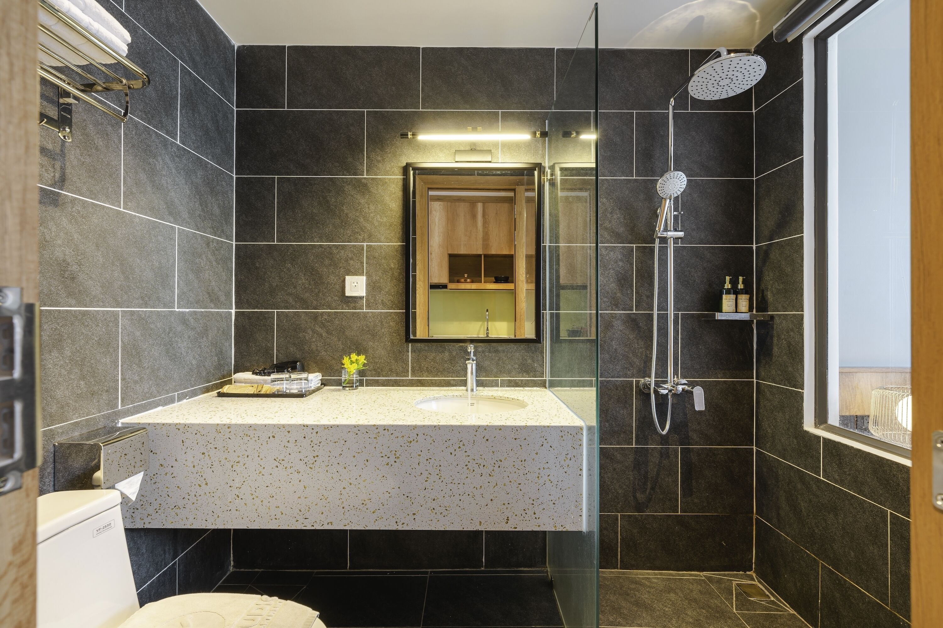 A modern bathroom with a freestanding sink, a glass-enclosed shower, and a large mirror above the sink.