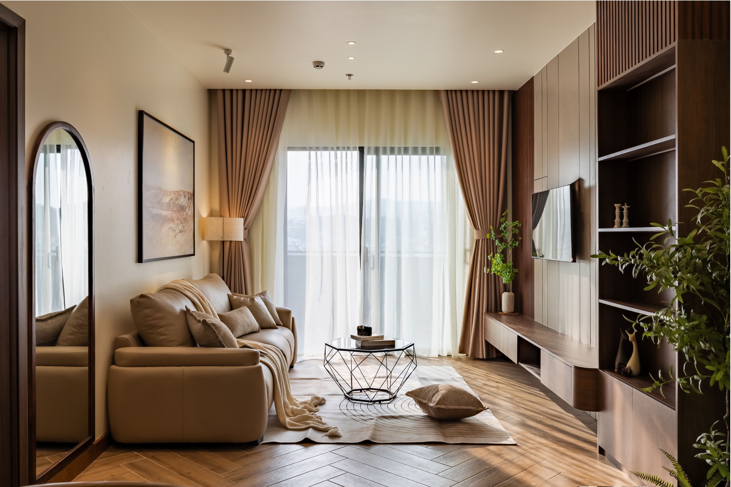 A modern living room with a sofa, a coffee table, and a TV on a wooden wall.