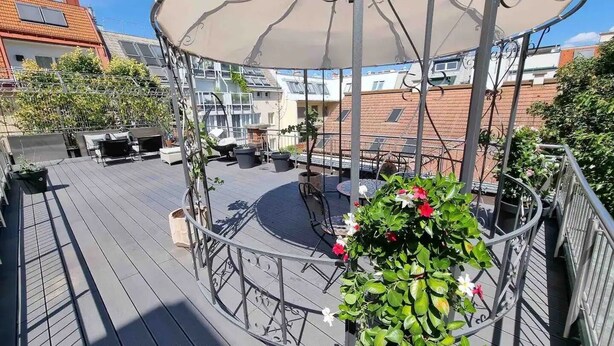 Une terrasse sur le toit dotée d’un espace salon circulaire, d’une pergola et de plantes en pot.