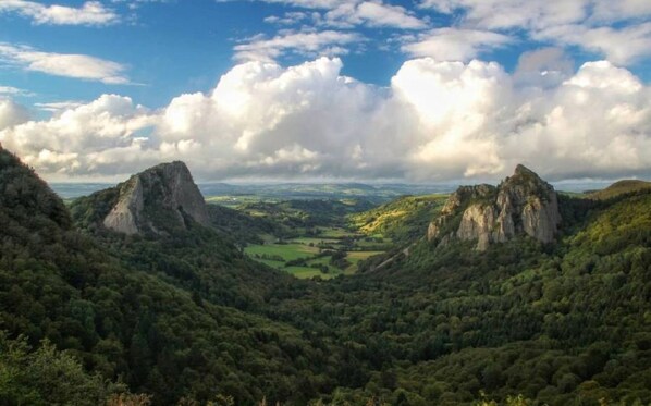 A mountainous landscape with prominent rock formations and a valley.