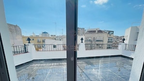 A rooftop terrace with a glass door, offering a view of the cityscape. - SL Hostel Marbella (Marbella)