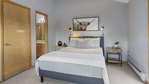 A bedroom with a bed, a nightstand, a bedside table, a mirror, a framed picture on the wall, and a door. - Private Sauna, Hot Springs Close, Monthly Discount (Durango)