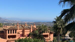 A resort with a swimming pool, palm trees, and a view of the city in the distance. -  El Soto de Marbella F/F Penthouse P20 Sea/Mountain Views.Onsite Golf-Gym-Tennis (AN)
