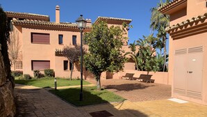A courtyard with a paved walkway, benches, and a tree. -  El Soto de Marbella F/F Penthouse P20 Sea/Mountain Views.Onsite Golf-Gym-Tennis (AN)