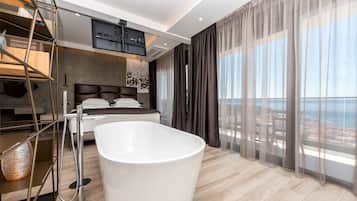 Ein modernes Schlafzimmer mit einer großen Badewanne, einem Bett und Meerblick.