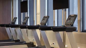 A gym with treadmills and a red exercise ball.