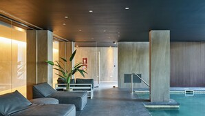 A modern indoor pool area with seating and a potted plant. - Almarena Puerto Retiro Affiliated by Melia (Buenos Aires)