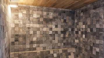 Relax in a stylish room with a unique tile design, wooden ceiling, and cozy seating area.