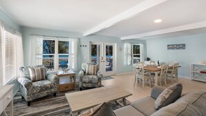 Un espacio habitable amplio con una mesa de comedor, sofás y vistas al exterior.