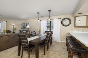 A dining area with a wooden table, chairs, and a bench along the wall.