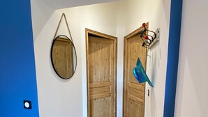 Ein Flur mit blauen Wänden, Holztüren und einem gefliesten Boden.