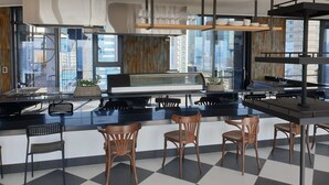 A modern kitchen with a central island, bar stools, and a view of the cityscape. - JUNIBINO HOTEL Hongdae (Seoul)