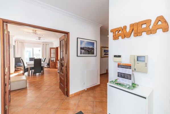 A hotel lobby with a dining area, a reception desk, and a sign that reads "TAVIRA".