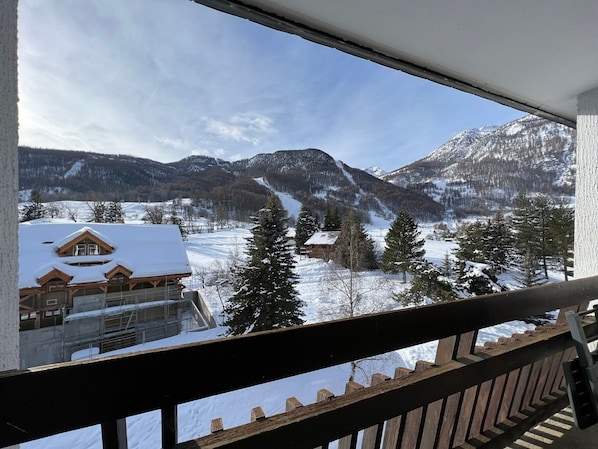 A mountain view with a wooden cabin and a ski slope.