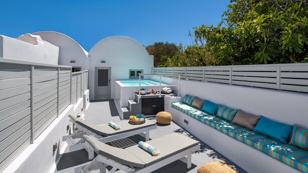A rooftop terrace with white walls, a pool, lounge chairs, and a sofa with striped cushions. - Amoramelia Suites (Santorini)