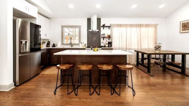 A modern kitchen with a central island, bar stools, and a dining table. - Cozy Escape! Modern/Luxe style w/2 Master en Suites-Fireplace-Fenced- SouthPark! (Charlotte)