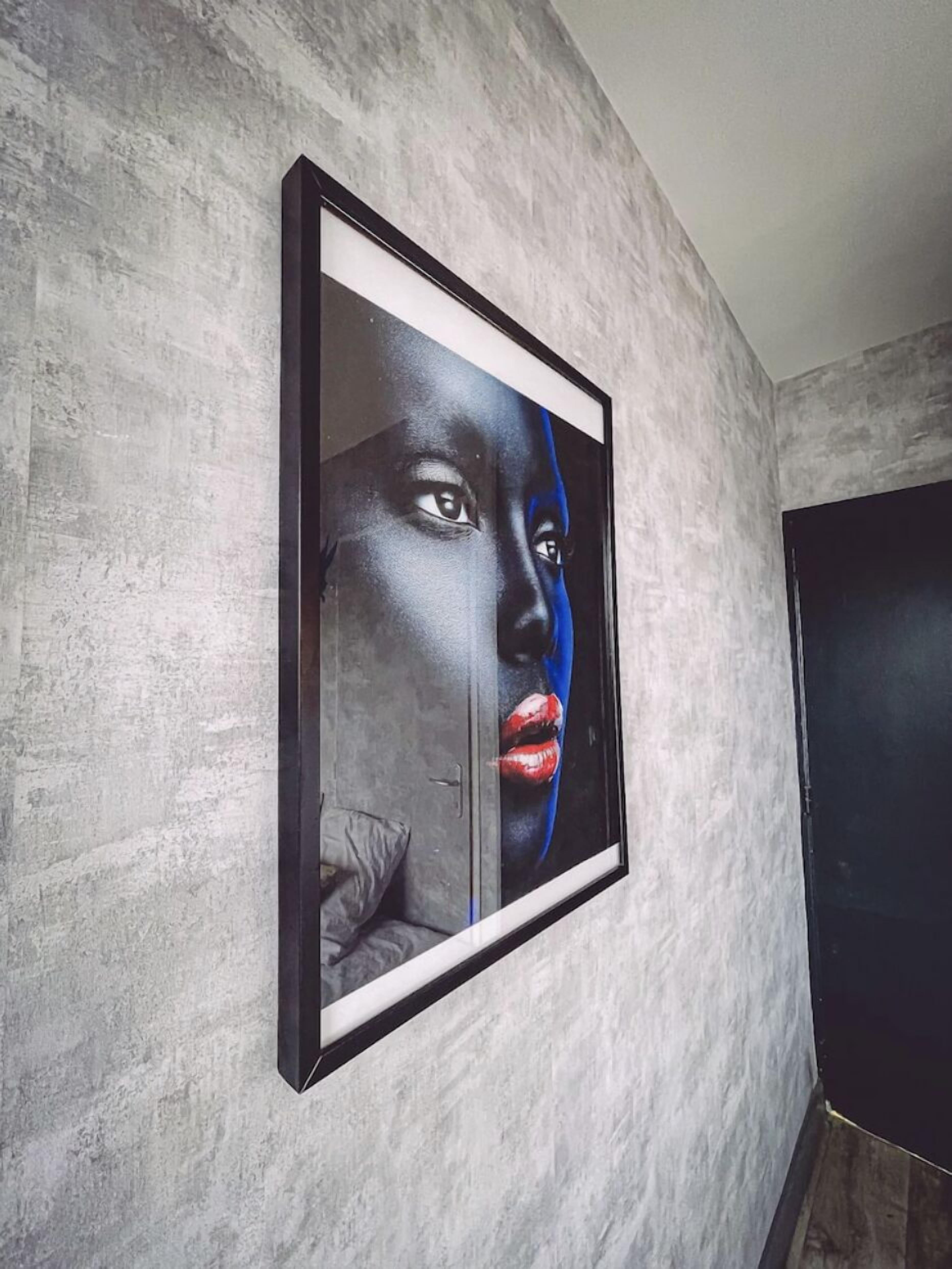 Ein gerahmtes Kunstwerk an einer strukturierten Wand.