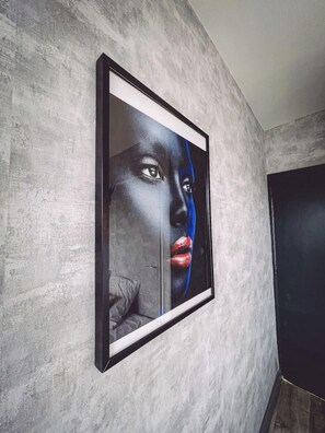 A framed artwork on a textured wall. - Appartement Tassigny Gare (Epinal)