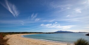 A beach with a clear sky and calm sea. - Marlin Waters 1 - Unit 1 Narira St 8 (Bermagui)