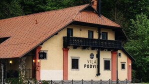 A building with a red-tiled roof and a sign reading "VILA PODVIL".