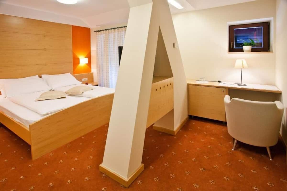 Ein Hotelzimmer mit Bett, Schreibtisch, Stuhl und Fenster mit Blick.