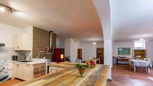 Eine geräumige Küche mit Holzarbeitsplatte, integriertem Backofen und einem Essbereich mit Tisch und Stühlen.
