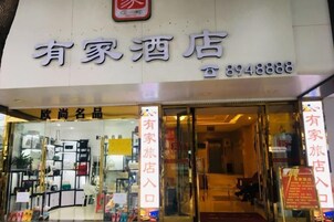 A hotel entrance with a signboard displaying the name and contact number.