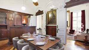 Comedor formal con una mesa de madera dispuesta para seis personas, sillas a ambos lados y un espejo grande en la parte superior.