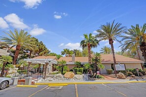 A hotel with a tiled roof, palm trees, and a parking area with yellow lines. - Lovely 2br 2bath Condo Next To Palms with free parking (Las Vegas)
