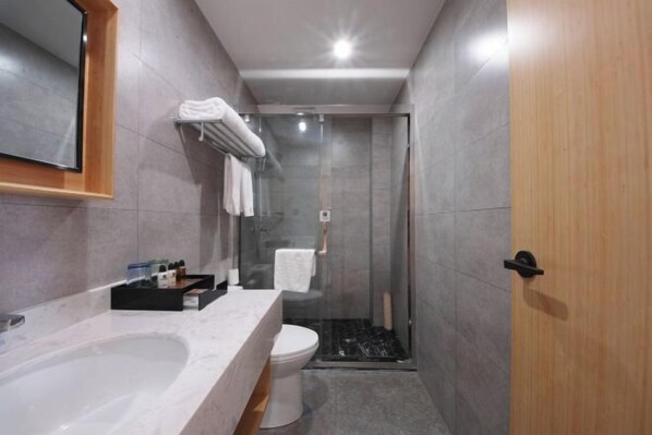 A modern bathroom with a large bathtub, a toilet, and a glass-enclosed shower. - Zhongyou Holiday Hotel (Feidong)